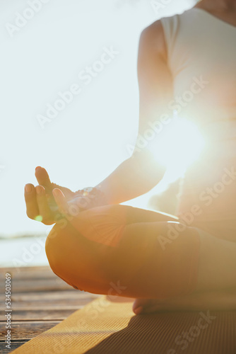 Photography Close-up of a yogi woman sitting in a lotus pose and meditating.