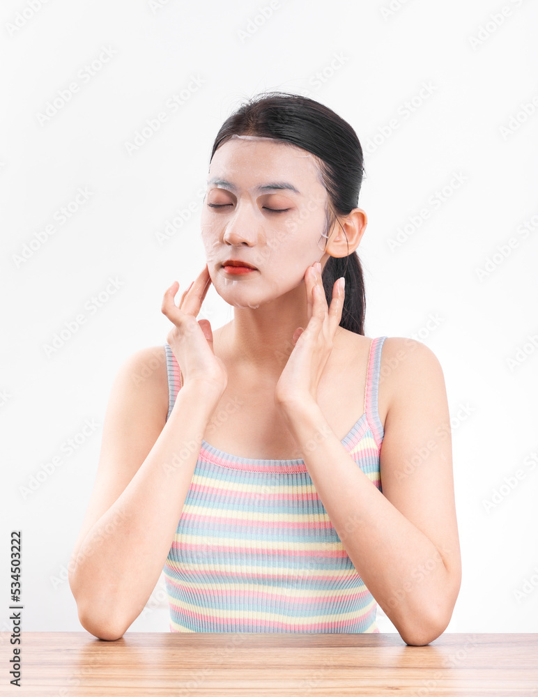 A young woman wearing a facial mask against a white background A young woman wearing a facial mask against a white background