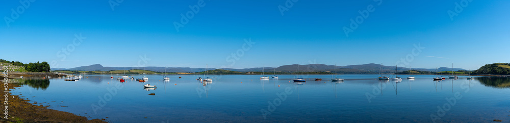 panorama view of  Bantry Bay in County Cork with many colorful sailboats anchored in the calm waters