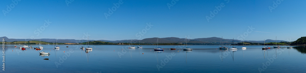 panorama view of  Bantry Bay in County Cork with many colorful sailboats anchored in the calm waters