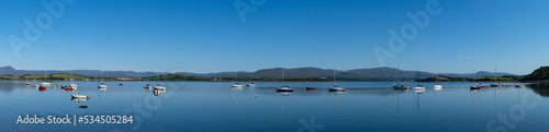panorama view of Bantry Bay in County Cork with many colorful sailboats anchored in the calm waters