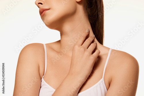 Cropped image of tender female body, neck, chin, collarbone isolated over white background. Skincare