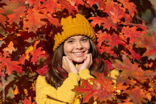 Teen child girl on autumn fall leaves background. cheerful teen kid in hat at fall leaves on natural background