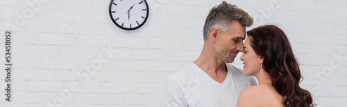 Side view of smiling couple standing with closed eyes at home, banner. © LIGHTFIELD STUDIOS