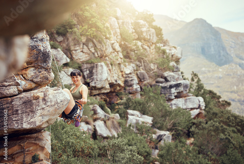Foto Mountain, rock climbing and sport with a sports woman and climber abseiling outdoor in nature