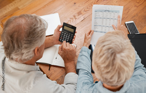 Budget, finance and senior couple with calculator planning financial investments, mortgage and tax papers. Elderly woman counting bills, debt and pension fund on bank statement with partner at home photo