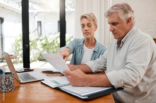 Retirement couple budget, finance and investment planning, loan and paper bills for online banking at home. Senior man, woman and people reading tax money report, cash savings and admin document note