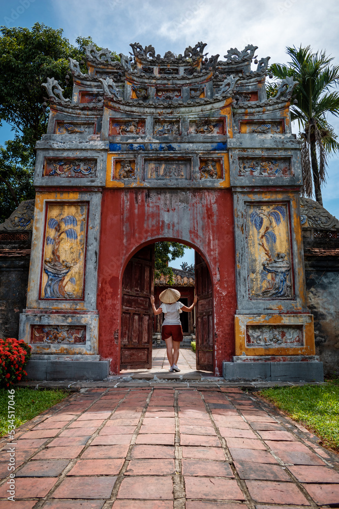 Mujer turista con sombrero vietnamita paseando por los interiores de la antigua capital imperial de Hue, en Vietnam