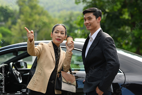 Portrait with Senior old age businesswoman talking with her partner after getting off the private car