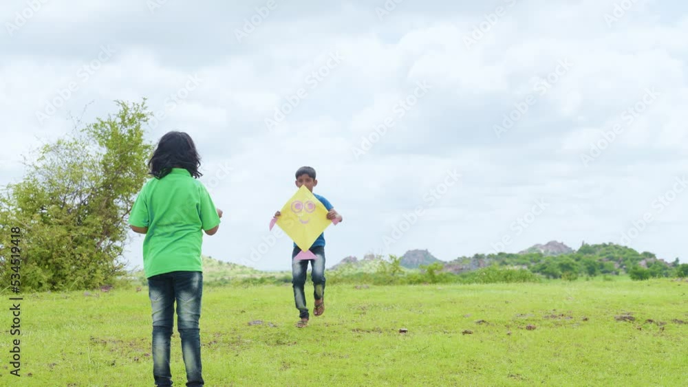 Excited teenager kids flying kite by enjoying on top of mountain - concept of hapiness, weekend and holidays activities. Excited teenager kids flying kite by enjoying on top of mountain - concept of hapiness, weekend and holidays activities.