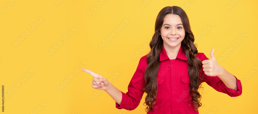 cheerful child girl pointing finger on copy space with thumb up gesture, success. Child face, horizontal poster, teenager girl isolated portrait, banner with copy space. cheerful child girl pointing finger on copy space with thumb up gesture, success. Child face, horizontal poster, teenager girl isolated portrait, banner with copy space.