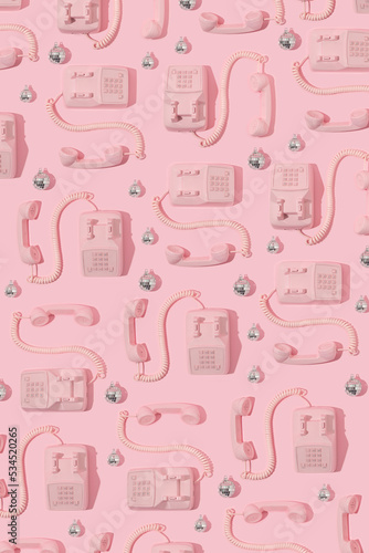 Creative pattern with pink retro phone and disco ball Christmas decoration on pastel pink background. 80s or 90s retro fashion aesthetic telephone concept. Romantic handset idea. 