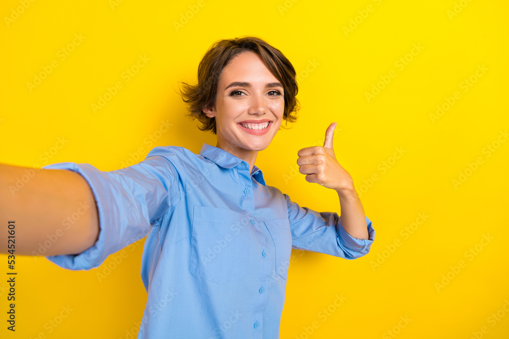 Closeup selfie photo of young pretty hipster woman brown bob hair cute smile blogger recommend new product sale isolated on yellow color background Closeup selfie photo of young pretty hipster woman brown bob hair cute smile blogger recommend new product sale isolated on yellow color background