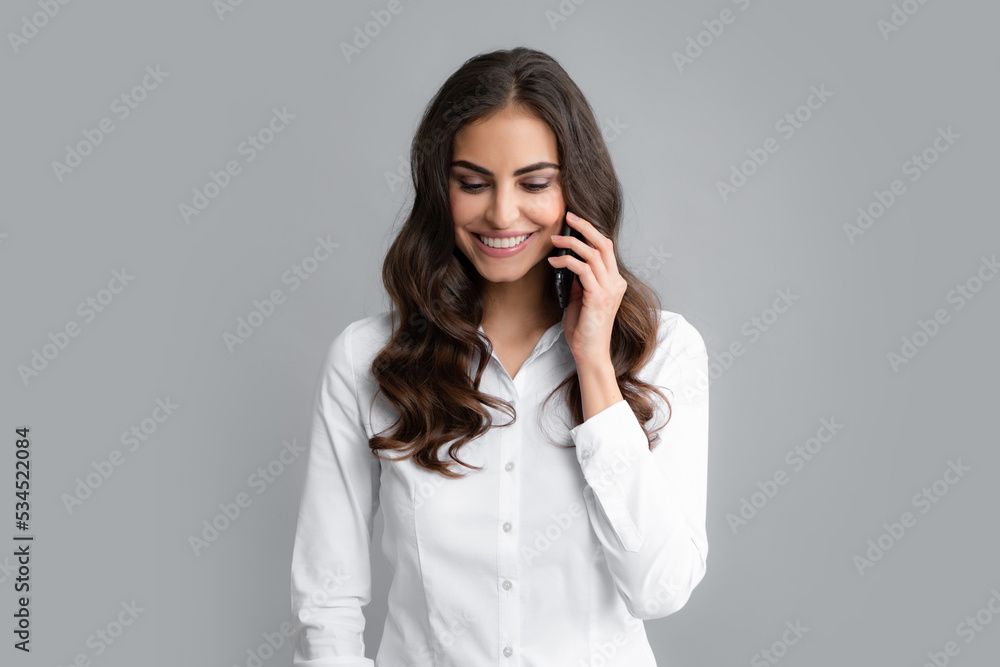 Happy positive smile woman with smartphone, chat, sms concept. Isolated over gray background. Mobile offer. Girl chatting by mobile phone. Happy positive smile woman with smartphone, chat, sms concept. Isolated over gray background. Mobile offer. Girl chatting by mobile phone.
