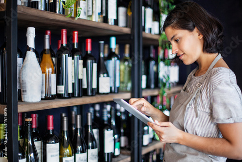 Wine shop owner setting up online store on digital tablet