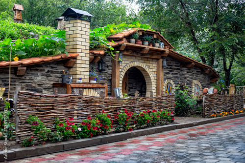 beautiful scenery, reminiscent of the hobbit house from the famous movie. Gnome near the wooden door photo