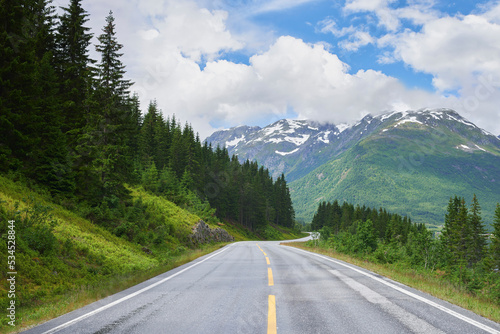 Road mountain, highway and countryside environment with freedom for travel, summer snow in Alaska and street or adventure. Landscape of calm driveway path in nature for transportation on holiday