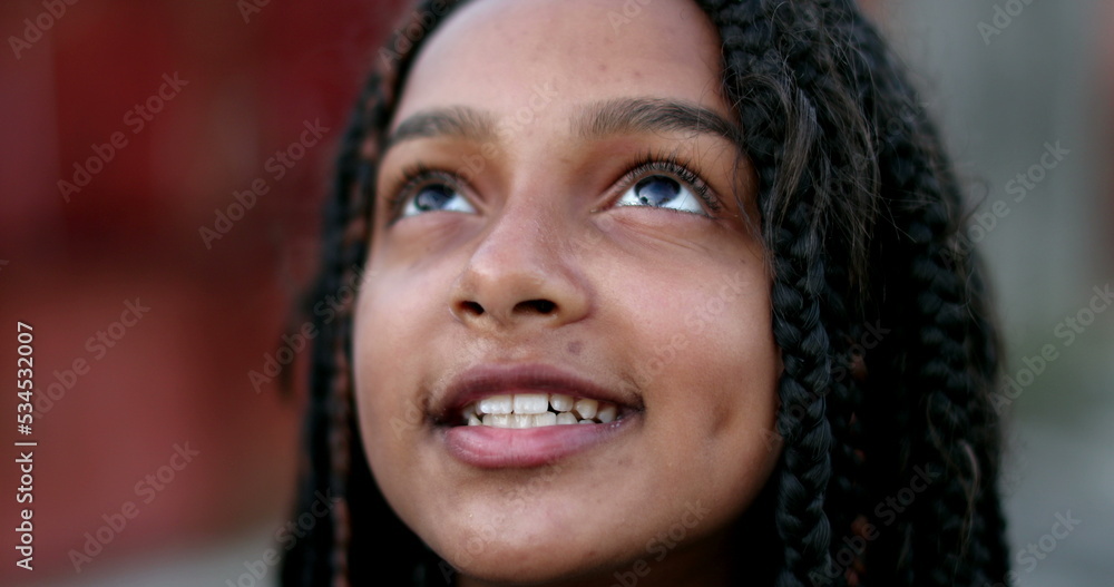 Happy hispanic black girl child opening eyes to sky looking up Happy hispanic black girl child opening eyes to sky looking up