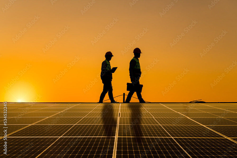 Engineers walking on roof inspect and check solar cell panel by hold ...
