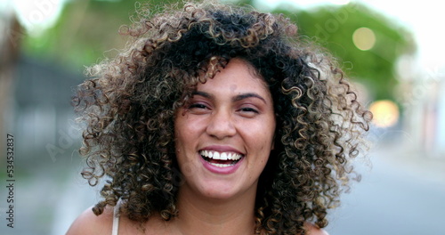 Happy Brazilian hispanic latina woman smiling to camera outside in street