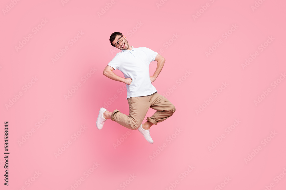 Full length photo of cheerful man jump enjoy travel vacation holiday relax rest without work empty space isolated on pink color background Full length photo of cheerful man jump enjoy travel vacation holiday relax rest without work empty space isolated on pink color background