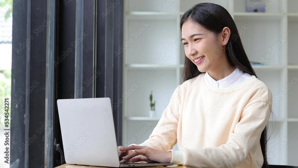 Attractive Asian woman at home enjoying typing using laptop and searching. Attractive Asian woman at home enjoying typing using laptop and searching.