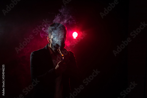 Photo of man smoking on pink background.