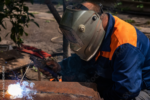 Worker wearing industrial uniforms and Welded Mask industrial safety first concept.