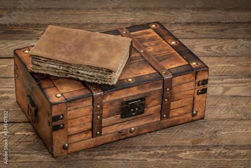 retro decorative case or storage box on wooden rustic table with am old journal or book photo