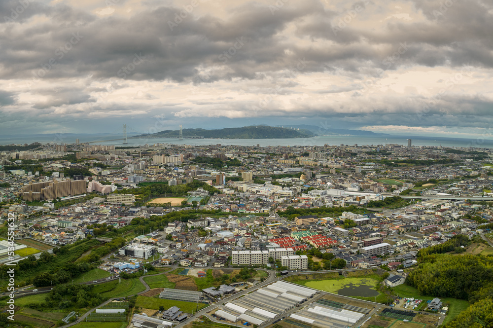 Aerial view of sprawling coastal town with storm clouds overhead