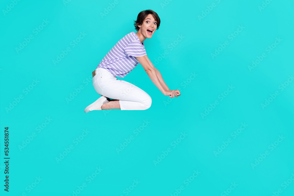 Full length photo of impressed funky girl dressed purple t-shirt flying empty space isolated teal color background