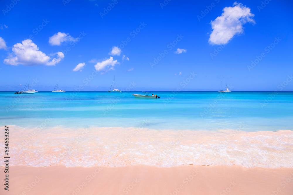 Obraz premium Tropical caribbean beach with sailboats and boat, Punta Cana, Dominican Republic