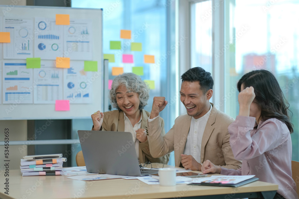 Obraz premium Group of Young Asian business team creative businesspeople coworker in office Happy to be successful partnership teamwork celebrating achievement and success concept.