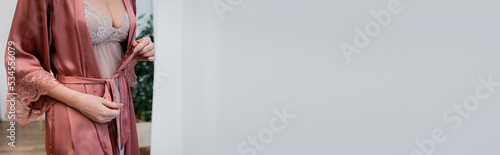 Canvastavla Cropped view of woman in nightie tying satin robe at home, banner
