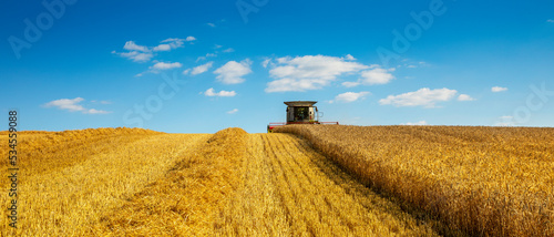 Moissonneuse au travail dans les champs de blé pendant les moissons en France. photo