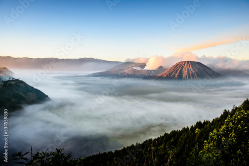 Mount Bromo volcano, a somma volcano and part of the Tengger mountains range, the cone rising above mist in the landscape. photo