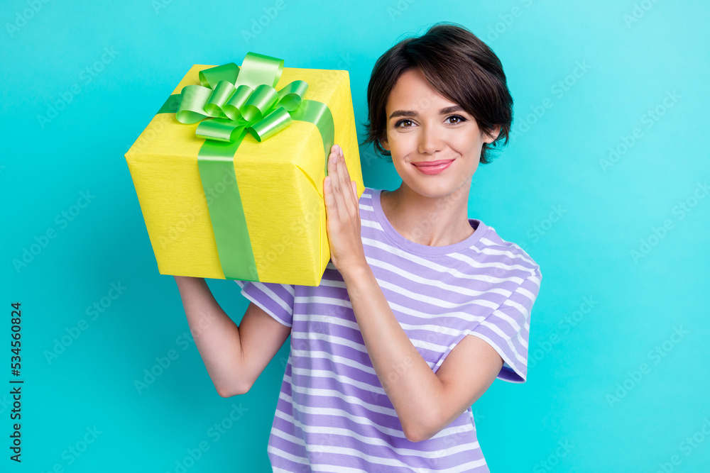 Photo of positive gorgeous woman with bob hairdo dressed striped t-shirt hold yellow gift box isolated on turquoise color background Photo of positive gorgeous woman with bob hairdo dressed striped t-shirt hold yellow gift box isolated on turquoise color background