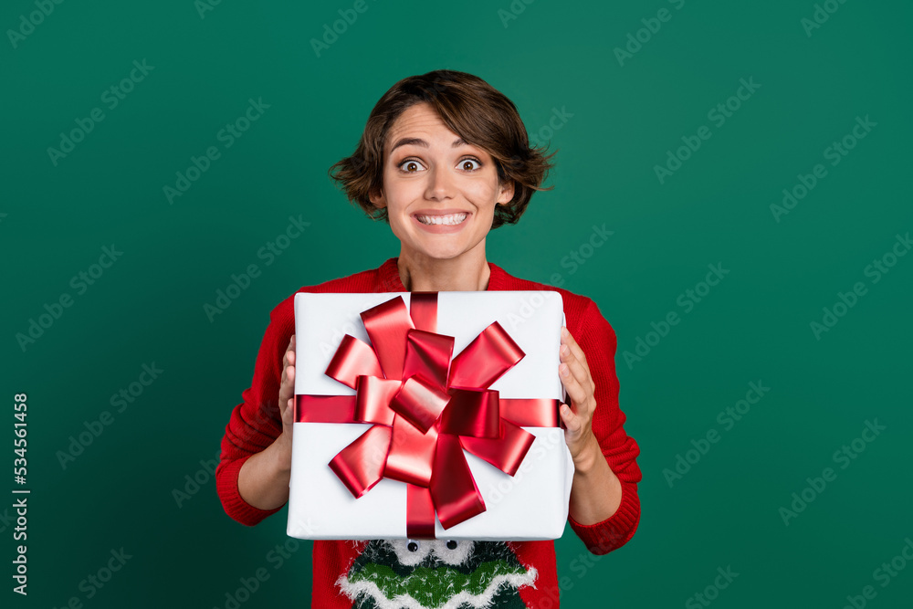 Photo of impressed brown hair millennial lady hold gift wear red pullover isolated on green color background Photo of impressed brown hair millennial lady hold gift wear red pullover isolated on green color background