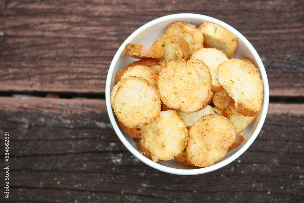 garlic breads in a bowl on wooden table garlic breads in a bowl on wooden table