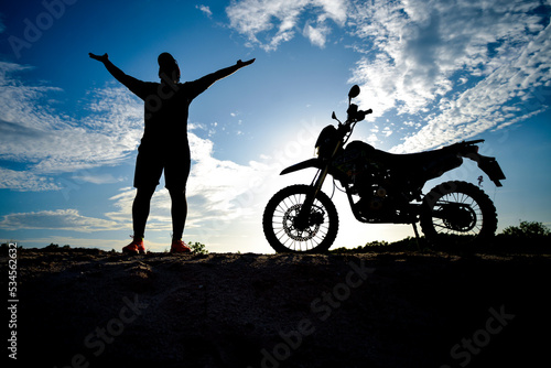 Silhouette Man enjoying a motocross bike on a beautiful evening in the mountains. © STOCK PHOTO 4 U
