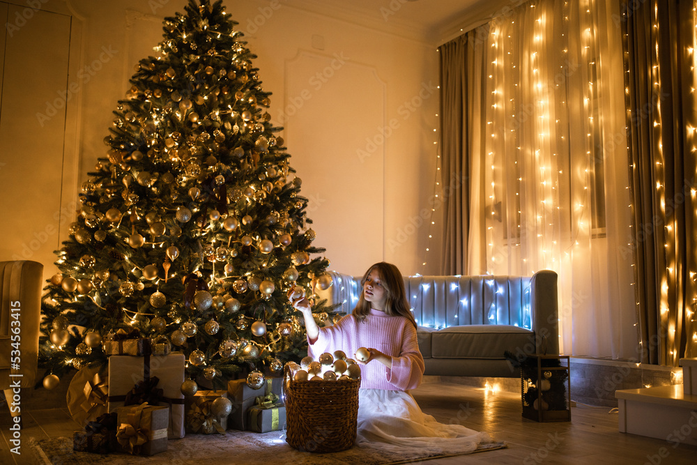 Cute teenage girl in a room with a decorated Christmas tree. The winter holidays. High quality photo