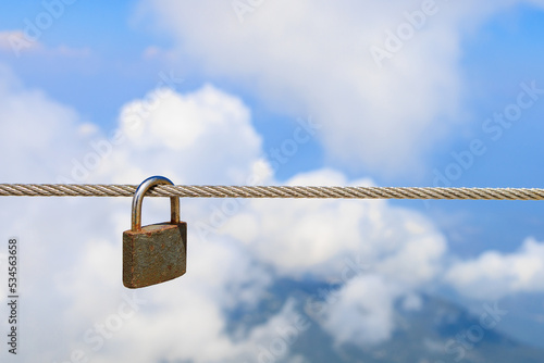 Padlock on a steel rope, selective focus. Background with copy space