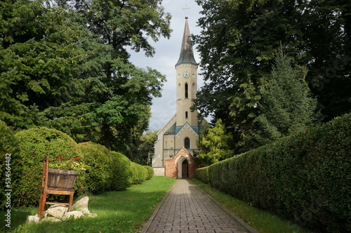 Entrance path to the temple. Saint Lawrence Church (kosciol pw. Sw. Wawrzynca) in background. Mikolow, Poland. photo