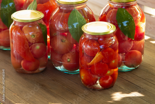 Preserves vegetables in glass on wood background, marinated fermented and pickled fermer food