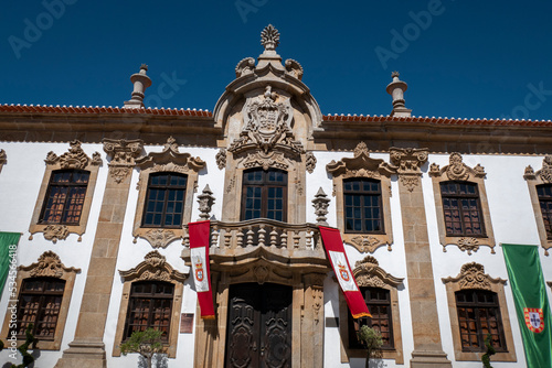 Casa brasonada com um belo brasão esculpido em granito na fachada principal numa vila de Portugal e com algumas bandeiras sobre a varanda e a fachada com as cores e o brasão da bandeira de Portugal
 photo