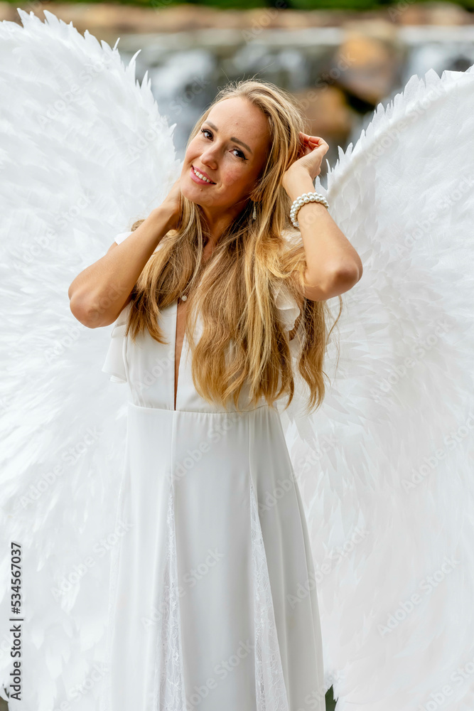 A Lovely Blonde Model Poses Outdoors While Wearing White Handmade Wings For Halloween A Lovely Blonde Model Poses Outdoors While Wearing White Handmade Wings For Halloween