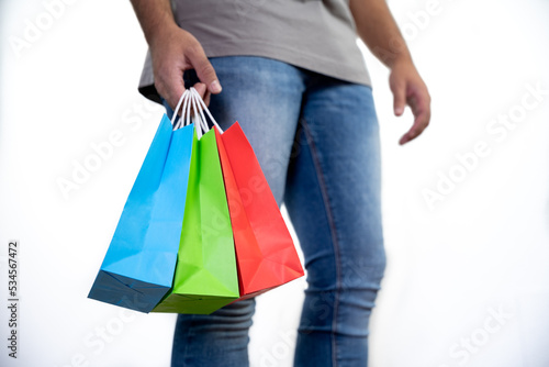 Unrecognizable young man holding some colorful bags - concept shopping, black friday, sales, christmas