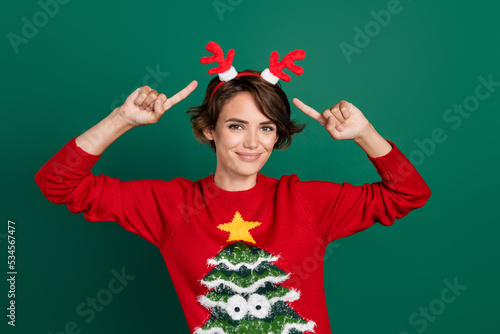Photo of funky funny girl dressed ugly print pullover pointing fingers deer hair band isolated green color background