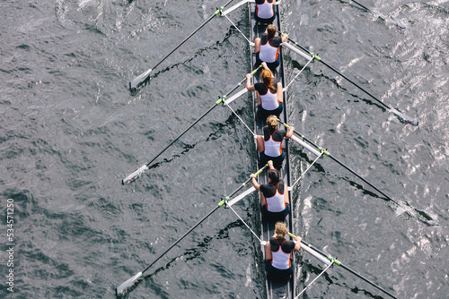 Overhead view of female crew racers rowing in an octuple racing shell, an eights team.