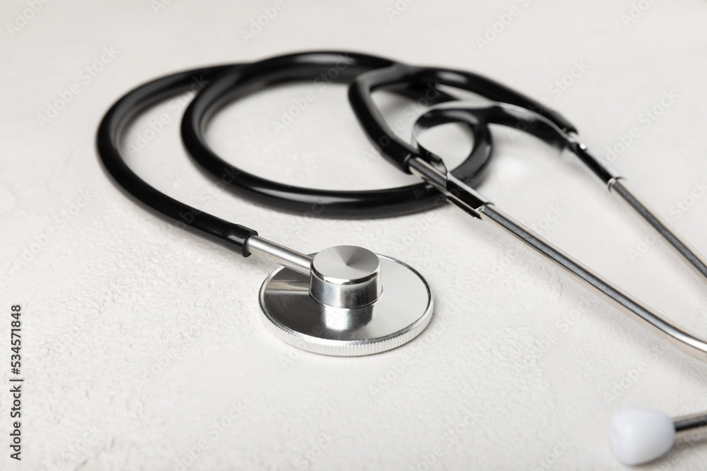 Black stethoscope on a gray background. Health care and medicine concept.health and doctor symbols.Close-up. Place to copy. Black stethoscope on a gray background. Health care and medicine concept.health and doctor symbols.Close-up. Place to copy.